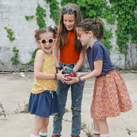 three girls holding a bunch of colorful hacky sacks together